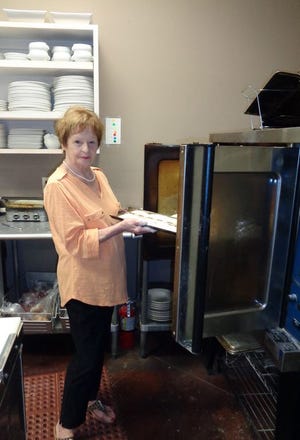 Hannelore Holland puts her fresh braided bread in the oven at Somethin's Cookin' in Panama City.