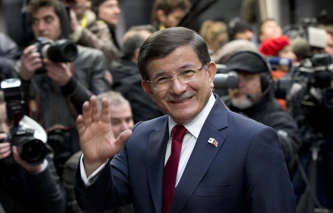 Turkish Prime Minister Ahmet Davutoglu waves as he arrives for an EU-Turkey summit at the EU Council building in Brussels on Sunday. AP Photo/Virginia Mayo