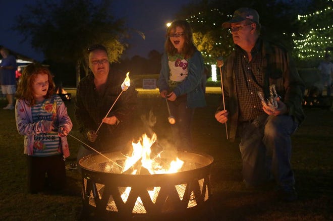 From left: Betty Depriest, 6, Patricia Voss, Amanda Depriest, 8, and Edward Coody Sr. roast marshmallows during Beach Home for the Holidays at Aaron Bessant Park on Saturday, Nov. 28, 2015, in Panama City Beach.