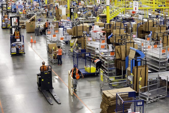 Workers fill orders at the Amazon fulfillment center on Cyber Monday, Dec. 1, 2014, in Lebanon, Tenn.