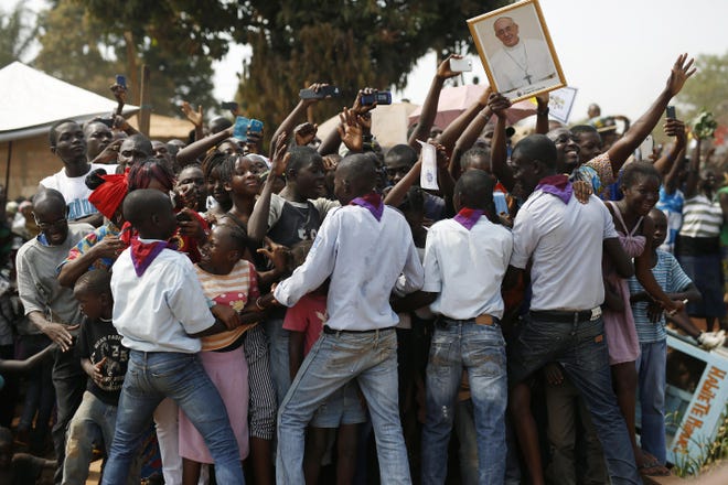 A crowds of people cheer at Pope Francis upon his arrival in Bangui, Central African Republic, Sunday, Nov. 29, 2015. The Pope has landed in the capital of Central African Republic, his final stop in Africa and where he will seek to heal a country wracked by conflict between Muslims and Christians. (AP Photo/Jerome Delay)