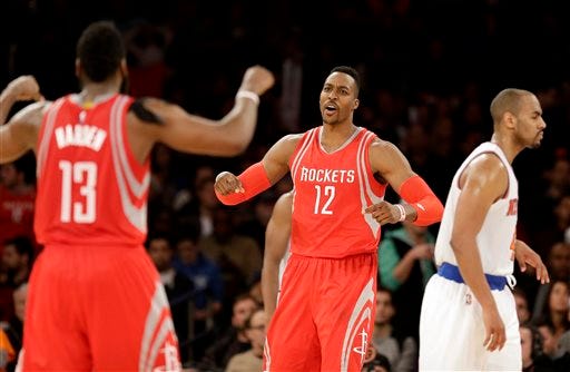 Houston Rockets' Dwight Howard, center, celebrates with James Harden, left, while New York Knicks' Arron Afflalo walks away during the overtime period of the NBA basketball game against the New York Knicks, Sunday, Nov. 29, 2015, in New York. (AP Photo/Seth Wenig)