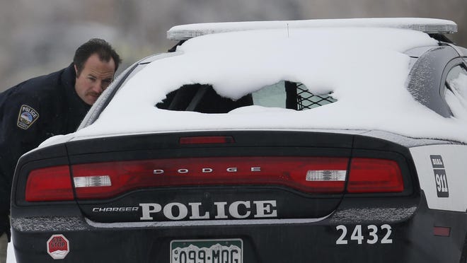 A crime scene investigator looks over a police vehicle damaged during Friday's shooting spree near a Planned Parenthood clinic Sunday, Nov. 29, 2015, in northwest Colorado Springs, Colo. (AP Photo/David Zalubowski)