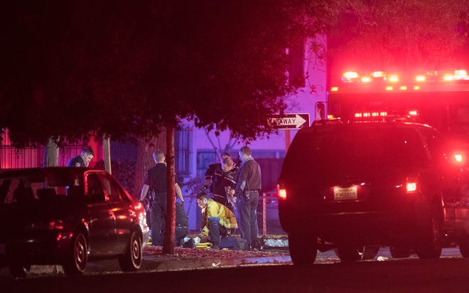 Stockton police and medical personnel tend to the victim of a deadly shooting at Oak and Edison streets in Stockton on Sunday night. The victim was identified as Richard Joseph "Richie" Burgos, 27. CRAIG SANDERS/FOR THE RECORD