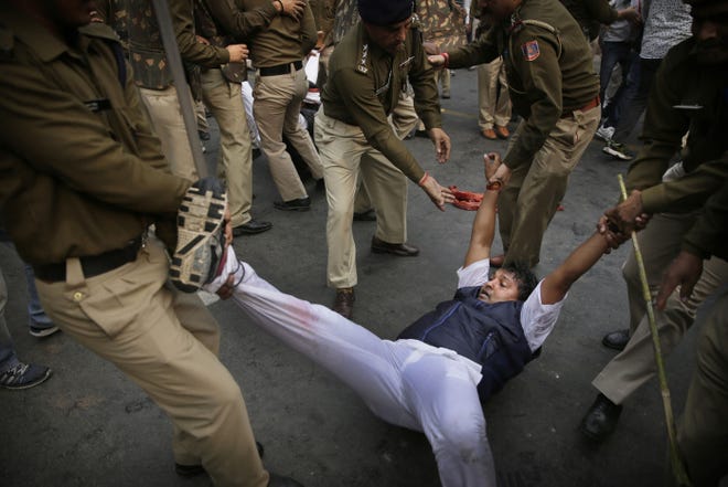 New Delhi policemen detain a protesting Youth Congress worker during a demonstration against what the party calls growing intolerance in India. The party said many in India are alarmed by a rising tide of religious intolerance and violence since Prime Minister Narendra Modi's right-wing party came to power last year.