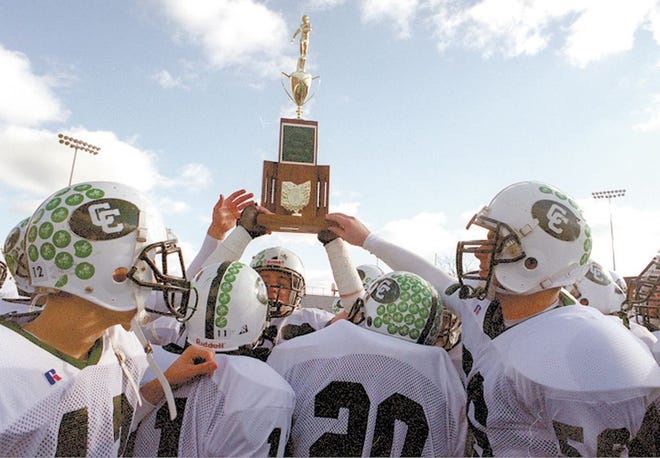 Central Catholic players hold up the OHSAA state championship trophy after winning the title in 2000 at Canton's Fawcett Stadium.