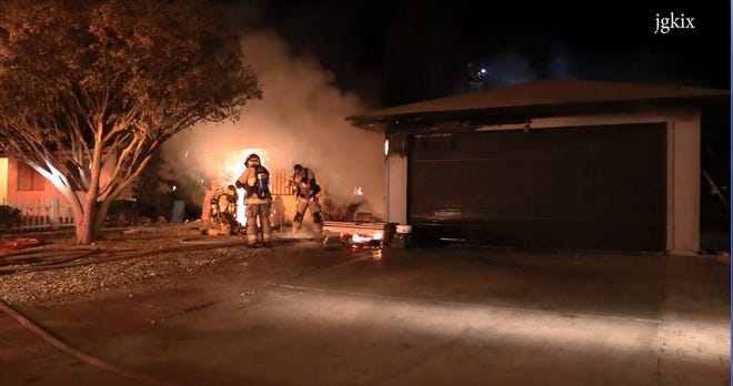 San Bernardino County Fire Department officials combat a fire that destroyed a Victorville residence Monday evening. (Video screen grab courtesy of Jose Gonzalez)