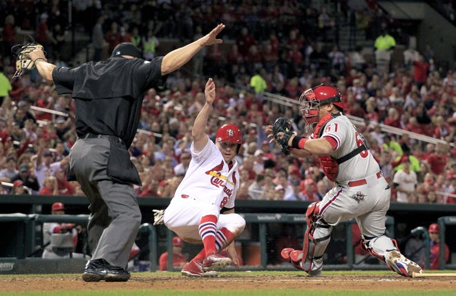 The Cardinals' Peter Bourjos (center) scores ahead of the tag from Phillies catcher Carlos Ruiz as home plate umpire Jeff Nelson makes the call during a game April 29 in St. Louis.