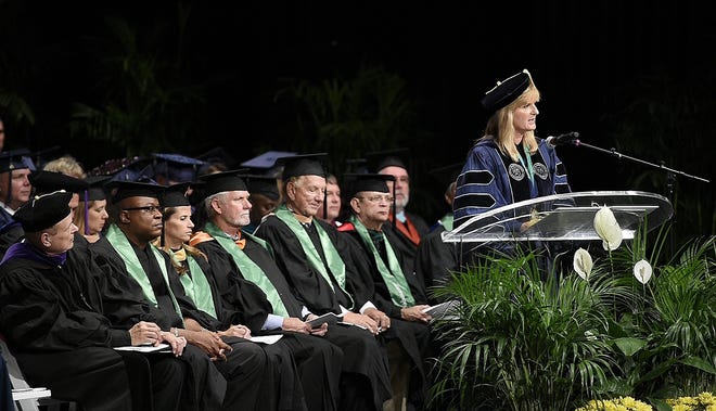 State College of Florida Board of Trustees members, wearing green stoles, attend the SCF Spring 2015 graduation ceremony in May. Pictured, left to right: Ed Bailey, chair; Lori Moran, vice chair; Rick Hager, Robert Long and Dr. Craig Trigueiro. Standing, SCF President Dr. Carol Probstfeld speaks to graduates and guests.