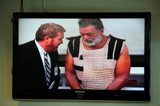 FILE - In this Nov. 30, 2015 file-pool photo, Colorado Springs shooting suspect, Robert Dear, right, appears via video before Judge Gilbert Martinez, with public defender Dan King, at the El Paso County Criminal Justice Center for this first court appearance, where he was told he faces first degree murder charges, in Colorado Springs, Colo. The man accused of killing three people at a Colorado Planned Parenthood clinic brought several guns, ammunition and propane tanks that he assembled around a car. To some in the community, the attack resembled an act of domestic terrorism, sparking a debate over what to call Robert Lewis Dear's rampage even before he was taken into custody. (Daniel Owen/The Gazette via AP, Pool, File)