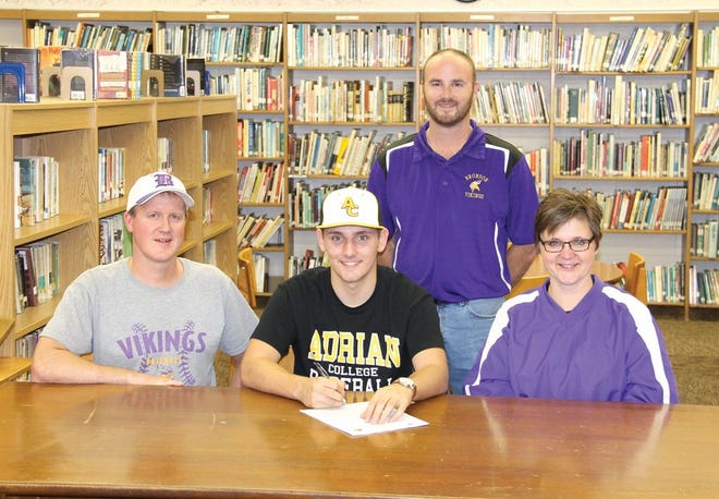 Daniel McMichael, center, signs his letter of intent to play college baseball at Adrian next year. He is pictured with parents Tadd and Amy McMichael along with head coach Matt Watkins.
