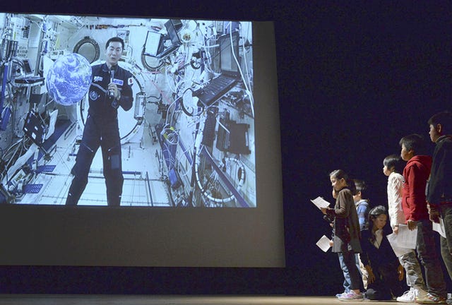 Japanese astronaut Kimiya Yui, left, holds a video talk with students in Kyoto on Tuesday; he is scheduled to return to Earth Dec. 11.