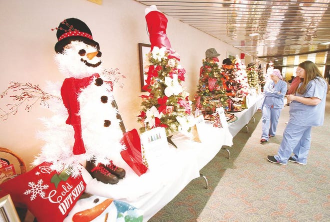 Lisa Lepsky R.N. and Shelby Varner from Affinity Medical Center's Heart Catherization Department look over the decorated and themed Christmas trees that are offered to employees and visitors by buying tickets and dropping them into the corresponding bags by each tree.