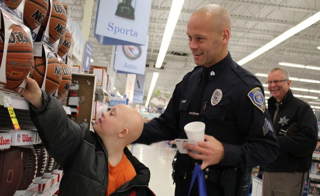 David West, 11, looks at basketballs with Ionia Department of Public Safety Detective Sgt. Cory McDiarmid Thursday at the Shop with a Hero event at Meijer. Ionia County Sheriff Dale Miller (right) looks on. 

Nicholas Grenke / Ionia Sentinel-Standard