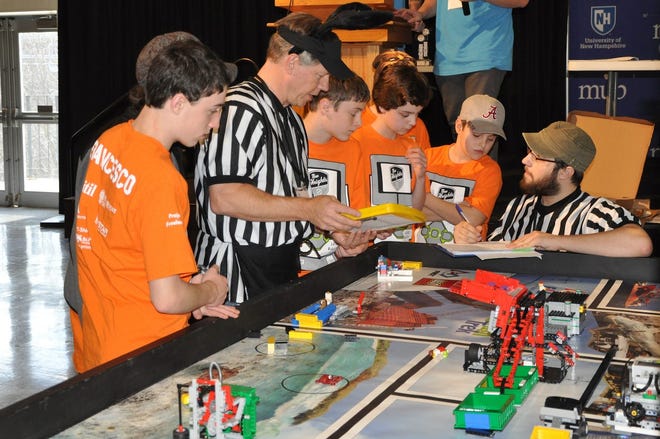 Members of the New Heights First Lego League robotics team Project Freelancer discussing their scores with the judges at the Seacoast qualifier competition in Durham. Project Freelancer is one of three teams from New Heights that advanced to the state competition on Dec. 5. (Courtesy photo)