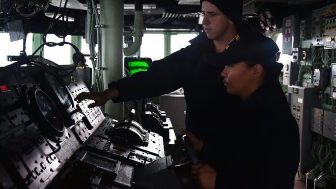 Seaman Timothy Covert of West Palm Beach, instructs Seaman Carline Binaro on her and responsibilities as helmsman aboard Arleigh Burke-class guided missile destroyer USS Stethem (DDG 63). Stethem is on patrol in the 7th Fleet area of operation in support of security and stability in the Indo-Asia-Pacific. (U.S. Navy photo by Lt. Matthew Comer)