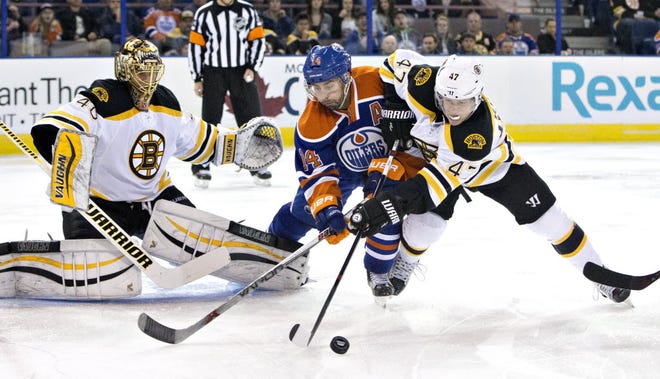 The Oilers' Jordan Eberle and the Bruins' Torey Krug battle for the puck as Tuukka Rask makes a save during the second period Wednesday night.