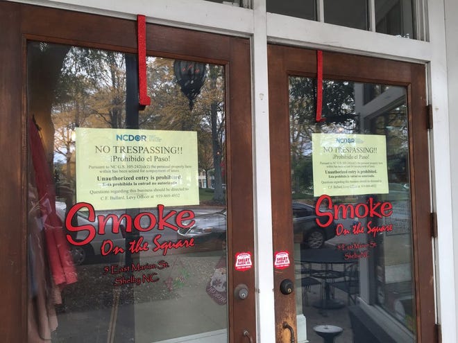 A sign on the door of Smoke on the Square reads the property has been seized due to unpaid taxes.