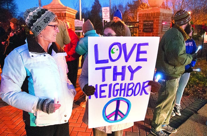 Evelyn Throne (left) and Sandra Kelsey, both of Middletown, attend a candlelight peace vigil Nov. 23 in Langhorne in honor of recent victims of terrorism.