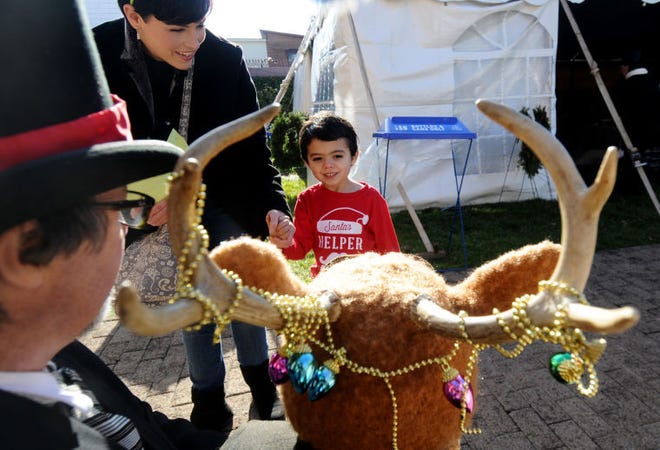(File) At last year's Victorian Holiday Celebration at Historic Smithville Park, Brady Umana, 5, of Pemberton Township, looks at Ralphie the Reindeer, with his handler Patrick Ahearn.