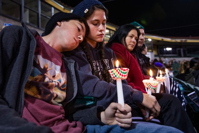 The McIntyre family from Redlands, Calif., hold candles at a vigil at San Manuel Stadium Thursday, Dec. 3, 2015, in remembrance of the 14 people lost Wednesday in the San Bernardino mass shooting. From left to right, Patrick,11, Kathleen, 13, (sister), Renee and Joe. The parents are middle school teachers. (Tom Tingle/The Arizona Republic via AP)