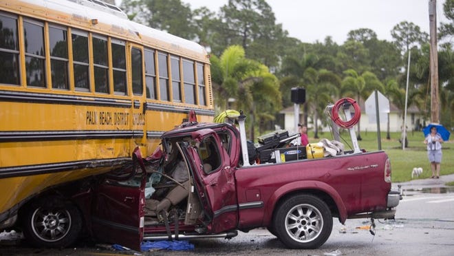 A truck collided with a school bus in The Acreage during the morning commute, Dec. 4, 2015. The man driving the truck was taken to the hospital and the three students on the bus escaped without injury. (Brianna Soukup / The Palm Beach Post)