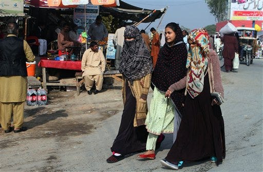 Pakistani women walk through a market in Karor Lal Esam, the hometown of California's female shooter Tashfeen Malik, about 450 kilometers (280 miles) southwest of Islamabad, Pakistan, Saturday, Dec. 5, 2015. Malik, who joined her U.S.-born husband in killing 14 people in a commando-style assault on his co-workers is now at the center of a massive FBI terrorism investigation. (AP Photo/Asim Tanveer)