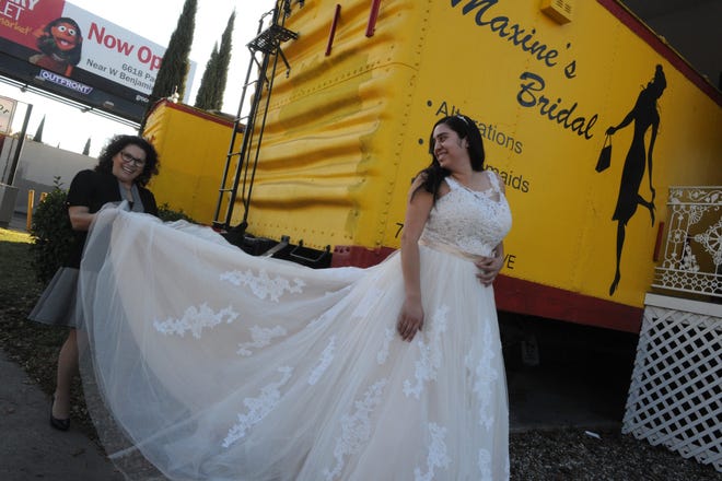 Maxine Bridal's Angela Reyes, left, with customer Cinthia Neri, 24, outside of her business located in two train refrigerator box cars along Pacific Avenue in Stockton. CALIXTRO ROMIAS/THE RECORD