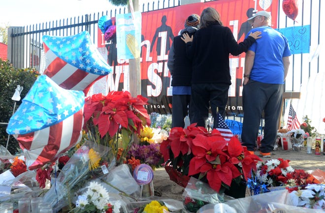 Members of The Way Church in San Bernardino offer prayers with visitors at a memorial for victims of the San Bernaridno County terror attacks on Monday in San Bernardino. A large memorial has been plaed a few blocks from the shooting scene. James Quigg, Daily Press