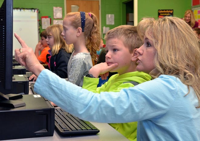 Lori Hampton, a teaching assistant at Hendersonville Elementary, helps Gibbon "Welles" Pender with the next step of an "Hour of Code" computer game project in the school's computer lab Monday morning. The class was part of an "Hour of Code" project taking place this week in schools all over the world.