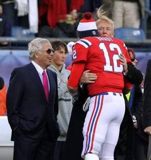Donald Trump gets a hug from Tom Brady, as Patriots owner Robert Kraft looks on, before a Jets-Patriots game in 2012.