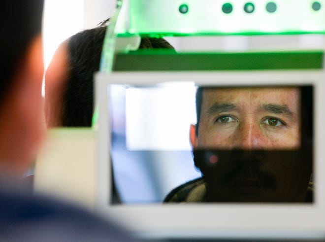 A pedestrian crossing from Mexico into the United States at the Otay Mesa Port of Entry has his facial features and eyes scanned at a biometric kiosk Thursday, Dec. 10, 2015, in San Diego. On Thursday, U.S. Customs and Border Protection began capturing facial and eye scans of foreigners entering the country at San Diego's Otay Mesa port of entry on foot.