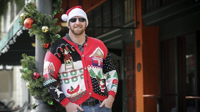 SunFest’s Josh Weiner, organizer of The Ugly Holiday Sweater Crawl, poses for a portrait in an ugly sweater on Clematis Street. (Bruce R. Bennett / The Palm Beach Post)