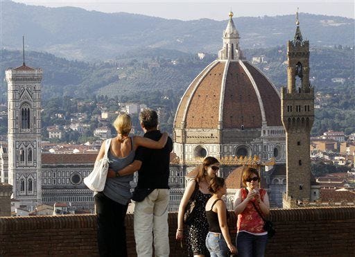 FILE - In this July 8, 2013 file photo, a couple looks at the Florence Santa Maria del Fiore Basilica, with Giotto's bell tower, left, Brunelleschi's dome, from Forte Belvedere, Italy. “When they get to these more dramatic occasions, so many couples want to do something exciting and different,” says Charles Schmitz of St. Louis. He and his wife, Elizabeth, are marriage counselors and authors, most recently of "How to Marry the Right Guy’’ (Briarcliff, 2014). (AP Photo/Francesco Bellini, File)
