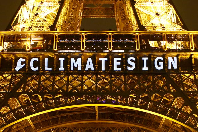 The slogan "CLIMATE SIGN" is projected on the Eiffel Tower as part of the COP21, United Nations Climate Change Conference in Paris, France, Friday, Dec. 11, 2015. (AP Photo/Francois Mori)