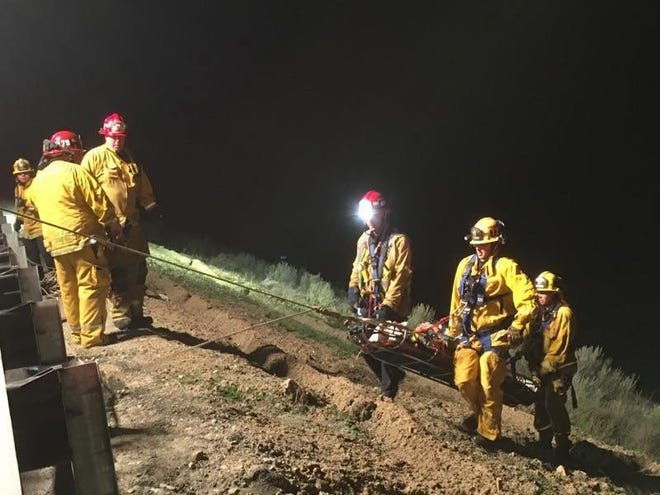 Firefighters extricated a man trapped in a tractor-trailer that went off Interstate 15 in the Cajon Pass and 250 feet down a steep embankment Thursday evening, officials said. The Ontario man suffered major injuries but is expected to survive. Photo courtesy of the San Bernardino County Fire Department