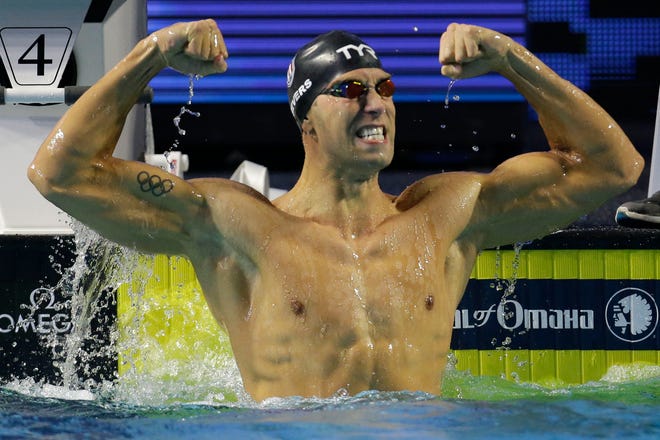Matt Grevers celebrates winning the men's 100-meter backstroke during the Duel in the Pool swim meet in Indianapolis, Saturday, Dec. 12, 2015. Grevers set a new world record with a time of 48.92 seconds.