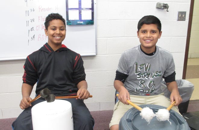Clinton Middle School sixth-grader percussionists Elias Montas (left) and Chris Garcia work with nontraditional instruments in preparing a piece called 'Christmas Stomp.' Photo for The Item