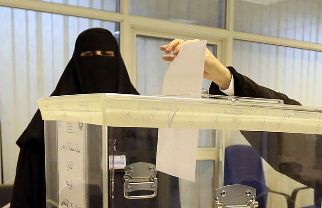Saudi women vote at a polling center during the municipal elections, in Riyadh, Saudi Arabia, Saturday, Dec. 12, 2015. Women across Saudi Arabia marked a historic milestone on Saturday, both voting and running as candidates in government elections for the first time, but just outside polling stations they waited for male drivers - a reminder of the limitations still firmly in place. (AP Photo/Aya Batrawy)
