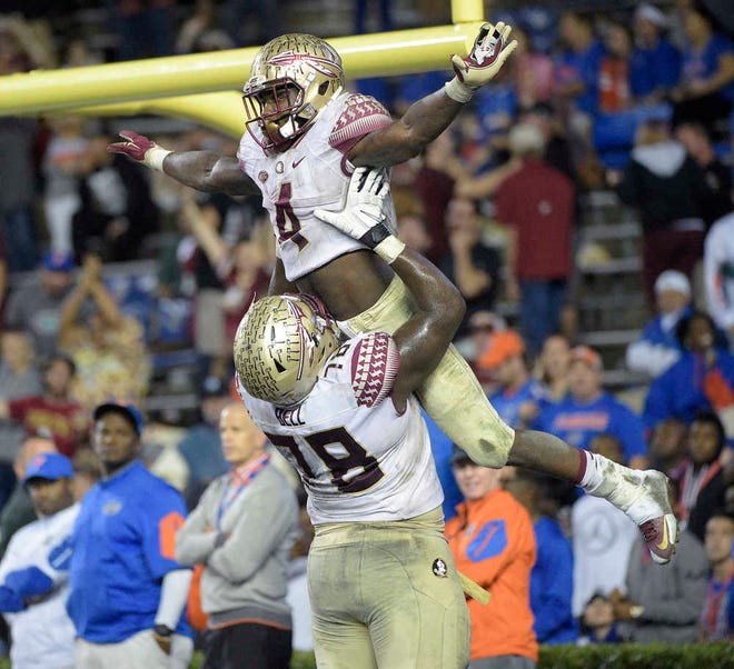 Florida State running back Dalvin Cook is congratulated by offensive lineman Wilson Bell after rushing for a 29-yard touchdown against Florida on Nov. 28 in Gainesville. Florida State won 27-2. (AP Photo/Phelan M. Ebenhack)