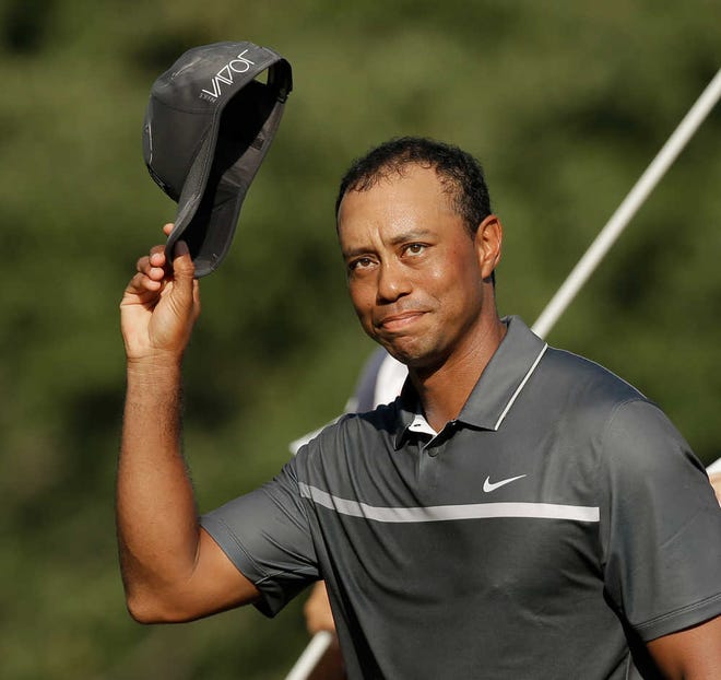 FILE - In this Aug. 21, 2015, file photo, Tiger Woods tips his hat to the crowd after finishing his round on the 18th hole during the second round of the Wyndham Championship golf tournament in Greensboro, N.C. Tiger Woods painted a bleak picture Tuesday, Dec. 1, 2015, on when he can return to golf or even get back to doing anything more than just walking. (AP Photo/Chuck Burton)