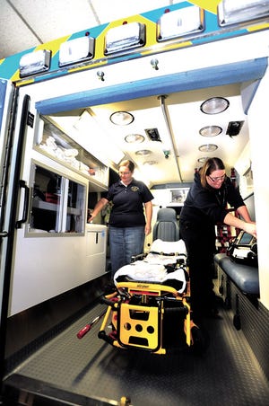 Swiss Valley Ambulance Station Leader Naomi Miller (left) and EMT Bre Kienzle check the back of an ambulance Monday at the Baltic Fire Department.