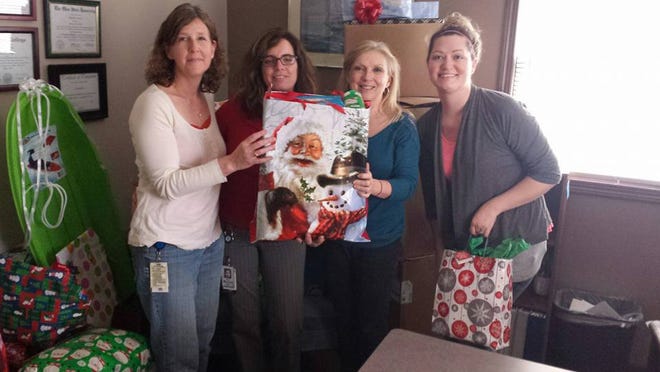 Marathon employees present Christmas gifts to Encompass Foster Care and Adoption staff members. From left: Julie Vinci and Michele Miller of Marathon Petroleum Company and Rhonda Greer and Hayla Clark of Encompass Foster Care and Adoption Services.
