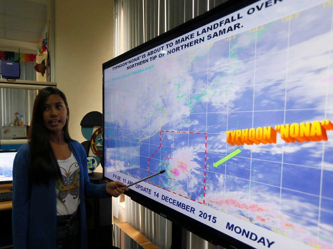 Government weather forecaster Loriedin De La Cruz briefs the media on Typhoon Melor at the weather bureau center in suburban Quezon city, northeast of Manila as it hits the eastern Philippines Monday, Dec. 14, 2015. Thousands of residents evacuated as the typhoon slammed into the eastern Philippines, where flood- and landslide-prone communities are bracing for destructive winds, heavy rains and coastal floods of up to 4 meters (13 feet), officials said Monday. (AP Photo/Bullit Marquez)