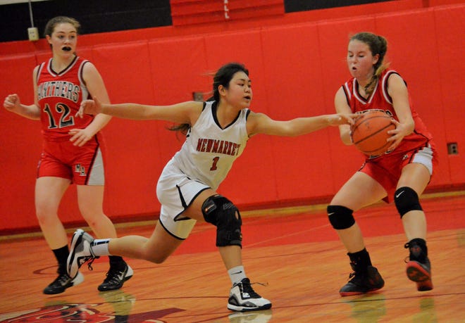 Newmarket High School sophomore Brenda Bounphakham (1) tries to steal the ball from Moultonborough's Liz Eaton as Megan Duddy (12) looks on during Monday's Division IV girls basketball game. Ryan O'Leary/Seacoastonline