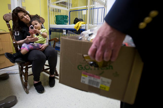 Christina McNabb holds her granddaughter, Avyanna Bennet, 2, after the Rev. Doug Williams from Aldersgate United Methodist Church dropped off a handmade wooden toy Tuesday, Dec. 15, 2015, at SwedishAmerican Hospital in Rockford. MAX GERSH/STAFF PHOTOGRAPHER/RRSTAR.COM