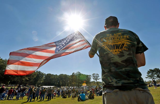 Nick Cooper holds an American flag during a rally at Brookwood Park in Brookwood, Ala. Wednesday, Oct. 14, 2015. Cooper works at Jim Walter Mine #7. Thousands of current and retired members of the United Mine Workers of America (UMWA), along with members of Congress and community supporters, participated in the rally to voice their disagreement with a potential cutoff of their benefits and to support pending legislation in Congress that would assist widows, injured workers and retired miners. staff photo | Michelle Lepianka Carter