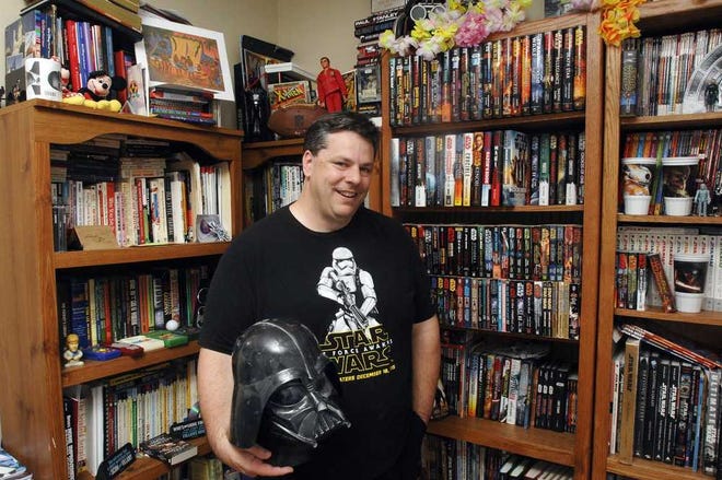 Photos by Terry.Dickson@jacksonville.com Scott Ryfun of Brunswick holds one of several Darth Vader helmets that are part of his collection of Star Wars items, which includes characters, comics and an "insane book collection."