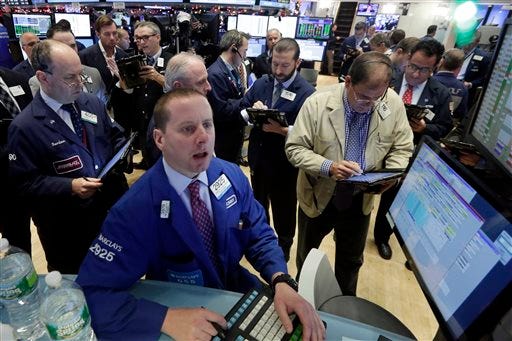 Specialist Robert Nelson, foreground, works with traders at his post on the floor of the New York Stock Exchange, Wednesday, Dec. 16, 2015. Stocks are opening higher, led by gains in banking shares ahead of an interest rate decision by the Federal Reserve. (AP Photo/Richard Drew)