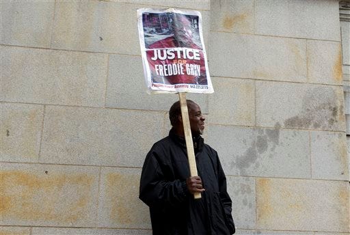 Arthur B. Johnson Jr. protests outside of the courthouse in response to a hung jury and mistrial for Officer William Porter, one of six Baltimore city police officers charged in connection to the death of Freddie Gray, Wednesday, Dec. 16, 2015, in Baltimore Md.